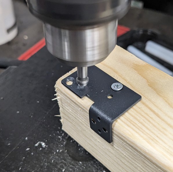 The metal bracket is held in place while drilling